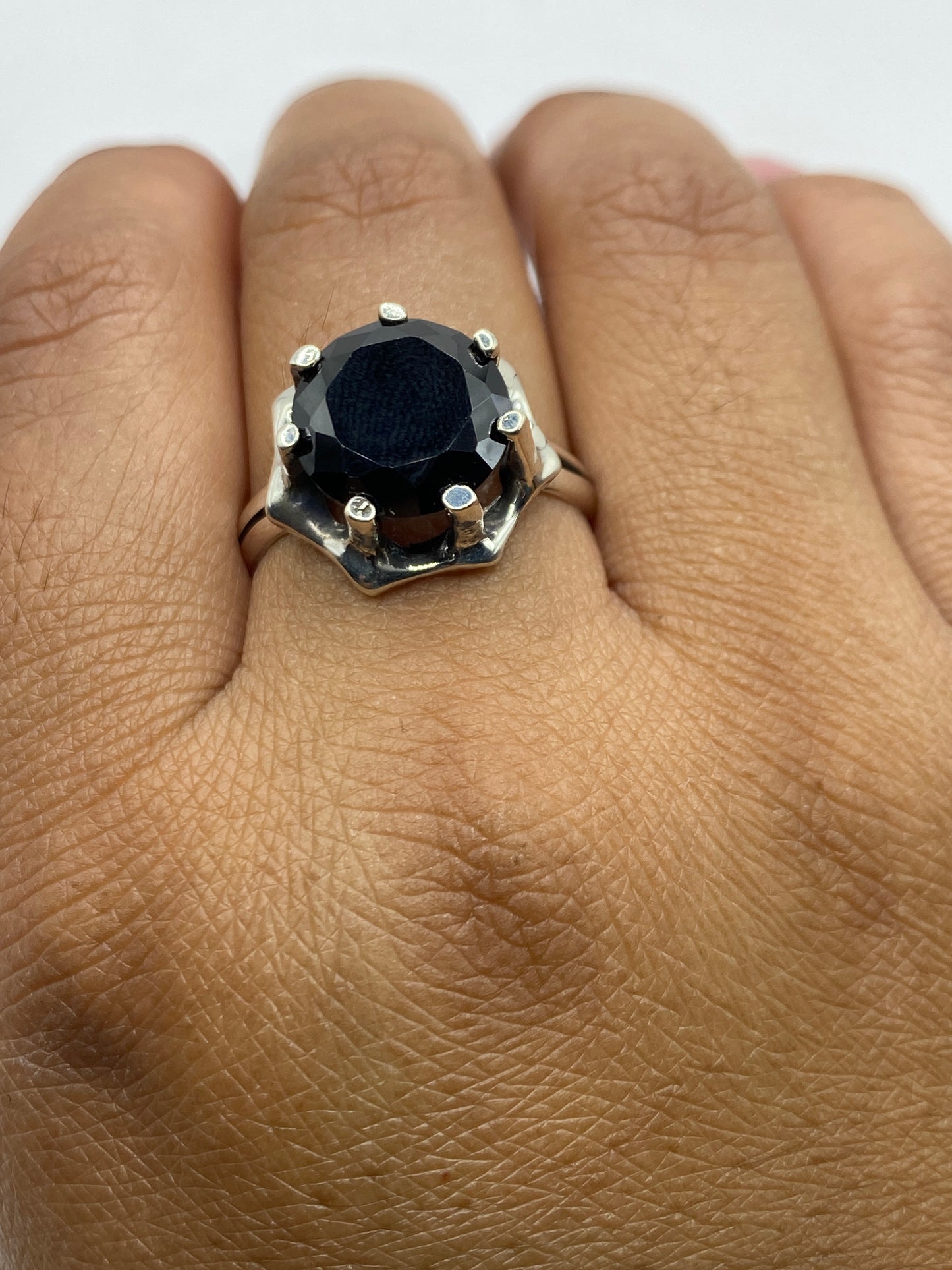 Anillo en la mano mostrando presencia y sofisticación, con sello .925 visible en la banda