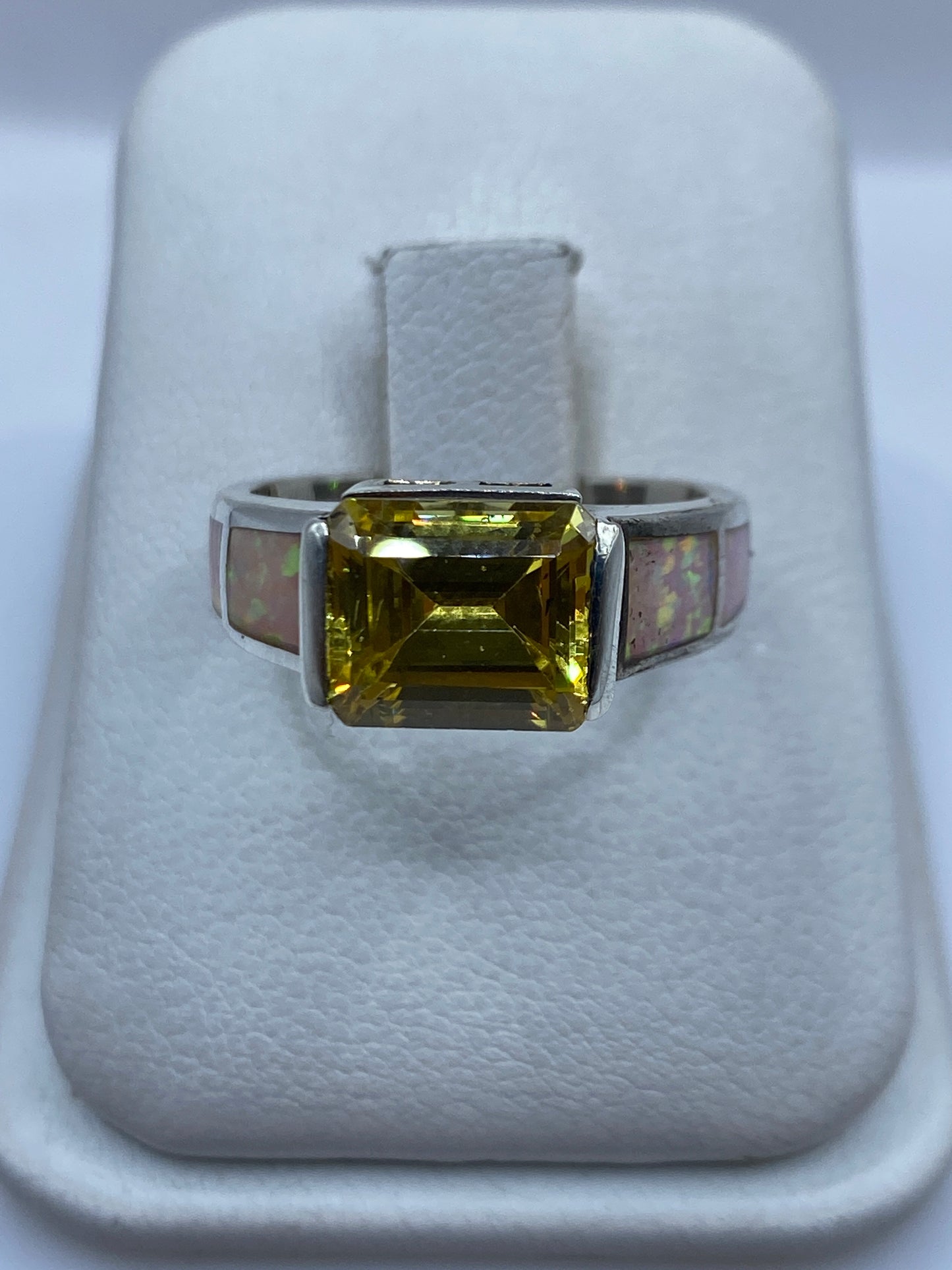 Anillo de plata .925 con ópalo de fuego multicolor en banda ancha, vista frontal sobre blanco