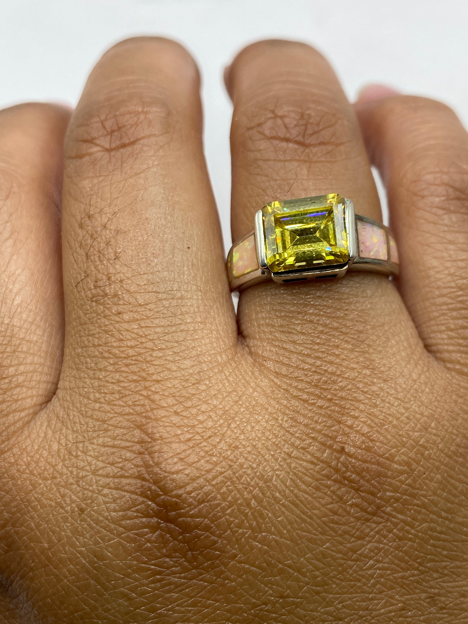 Anillo en mano de mujer mostrando la luminosidad natural del ópalo de fuego
