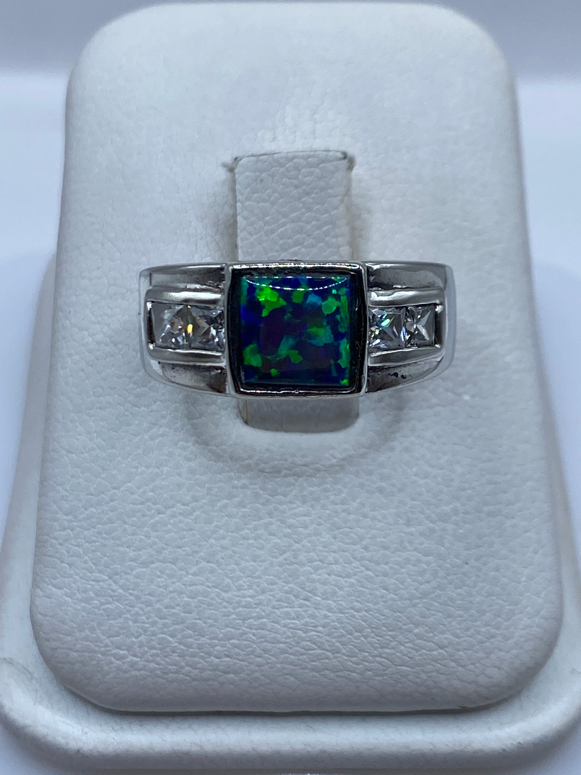 Anillo de plata .925 con ópalo de fuego azul sobre estuche blanco, vista frontal