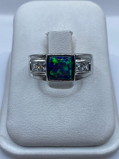 Anillo de plata .925 con ópalo de fuego azul sobre estuche blanco, vista frontal