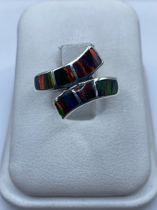 Anillo de plata con ópalo de fuego multicolor mostrando juego de colores naranjas, verdes y rojos