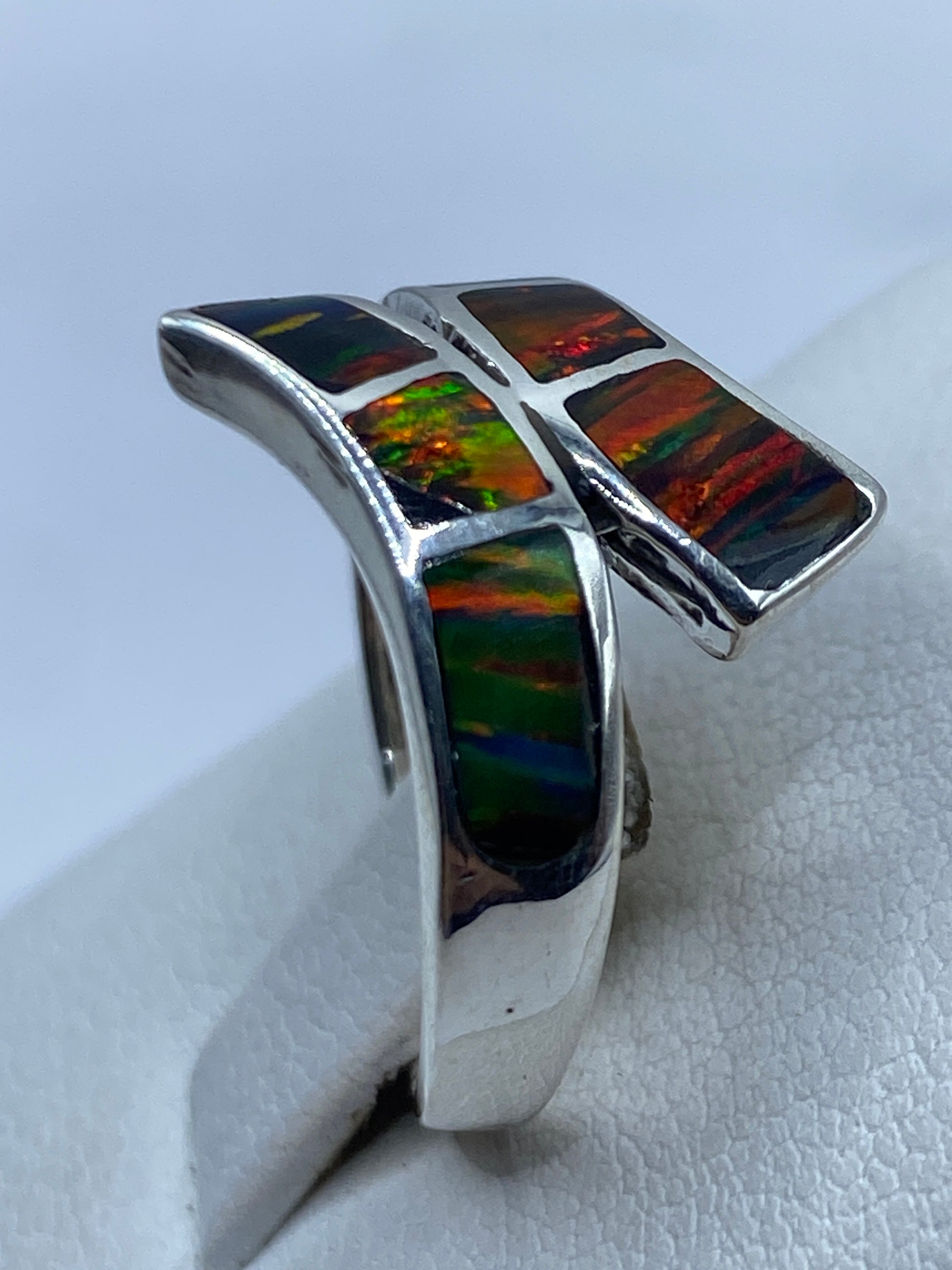 Anillo ópalo de fuego en mano de mujer adulta, mostrando brillo natural de la piedra