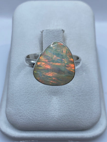 Anillo de plata .950 con ópalo de fuego ajustable mostrando juego de colores verde, amarillo y naranja
