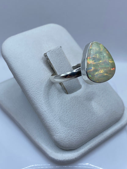 Detalle del ópalo de fuego natural con brillo multicolor en solitario de plata pura