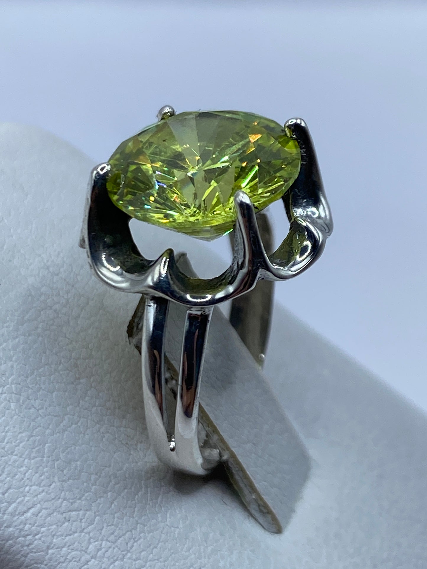Anillo de circonia verde en dedo de mujer mostrando el brillo de la piedra