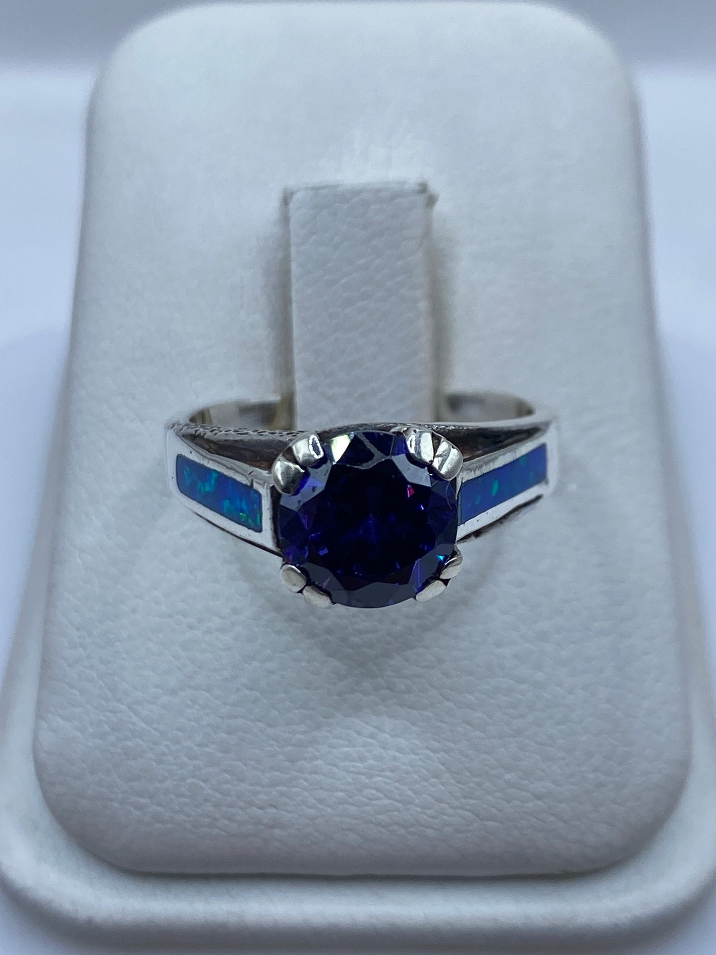 Anillo de plata .950 con ópalo de fuego azul en estuche blanco, vista frontal del engaste
