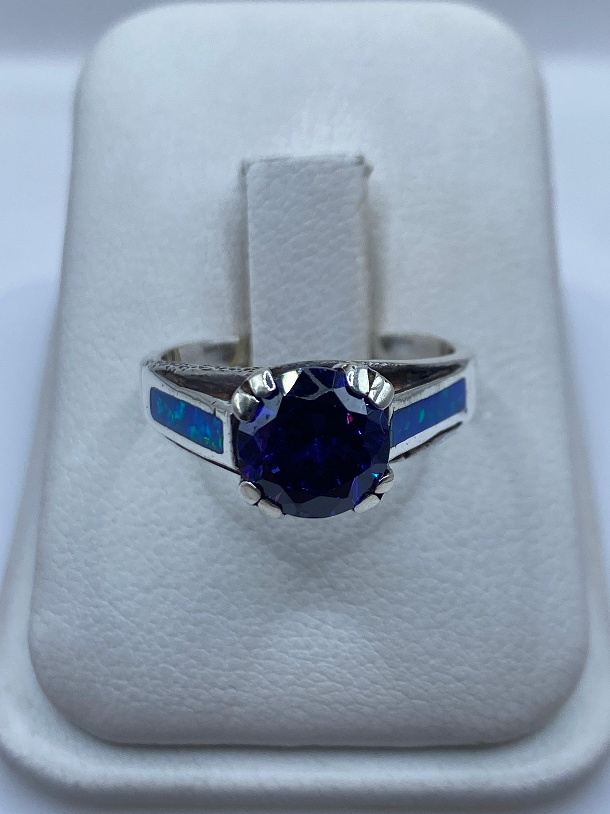 Anillo de plata .950 con ópalo de fuego azul en estuche blanco, vista frontal del engaste