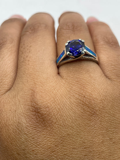 Anillo de ópalo de fuego azul con sello 950 visible, colocado en dedo mostrando tamaño real