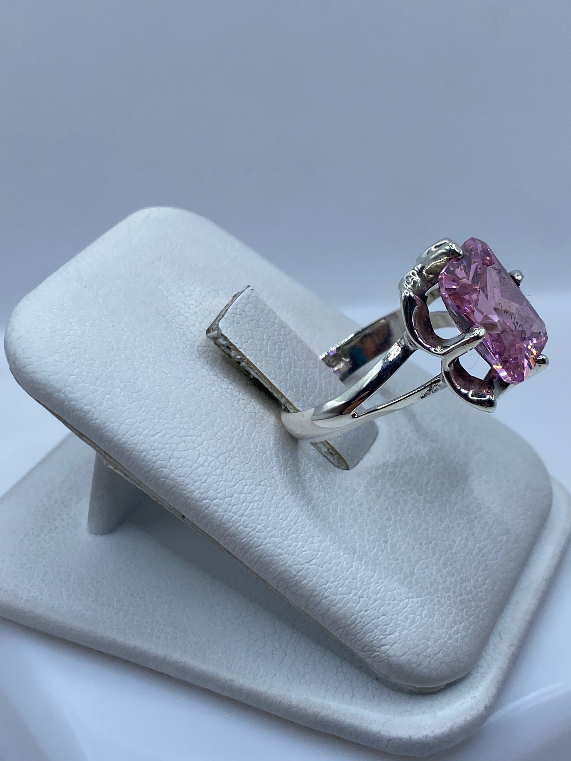 Anillo solitario circonia rosa en la mano de una mujer, mostrando brillo y fuego de la piedra