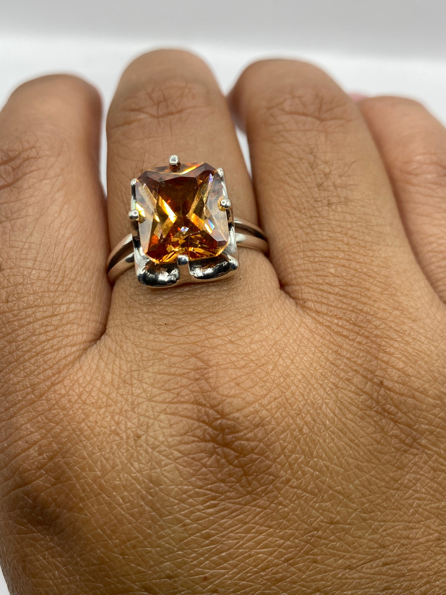 Anillo solitario sobre fondo blanco mostrando el sello 925 y el brillo de la piedra