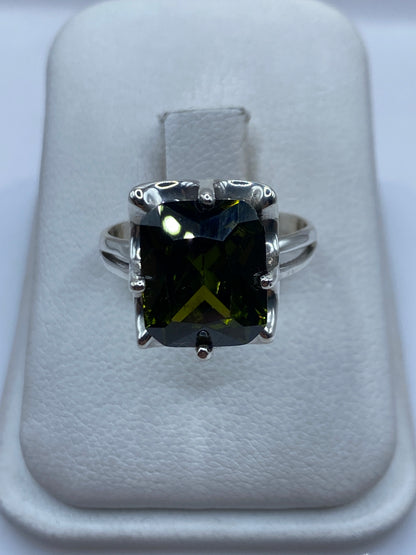 Anillo solitario de plata con circonia verde olivo facetada en dedo de mujer