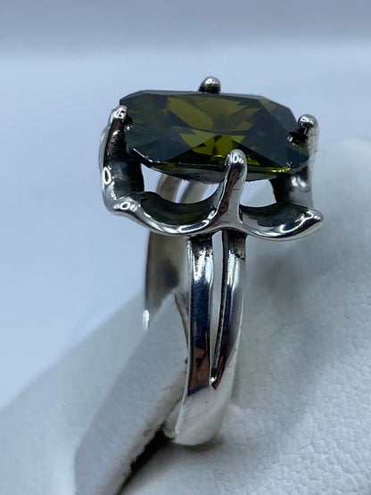 Detalle del engaste a mano de la circonia verde olivo en plata de Taxco