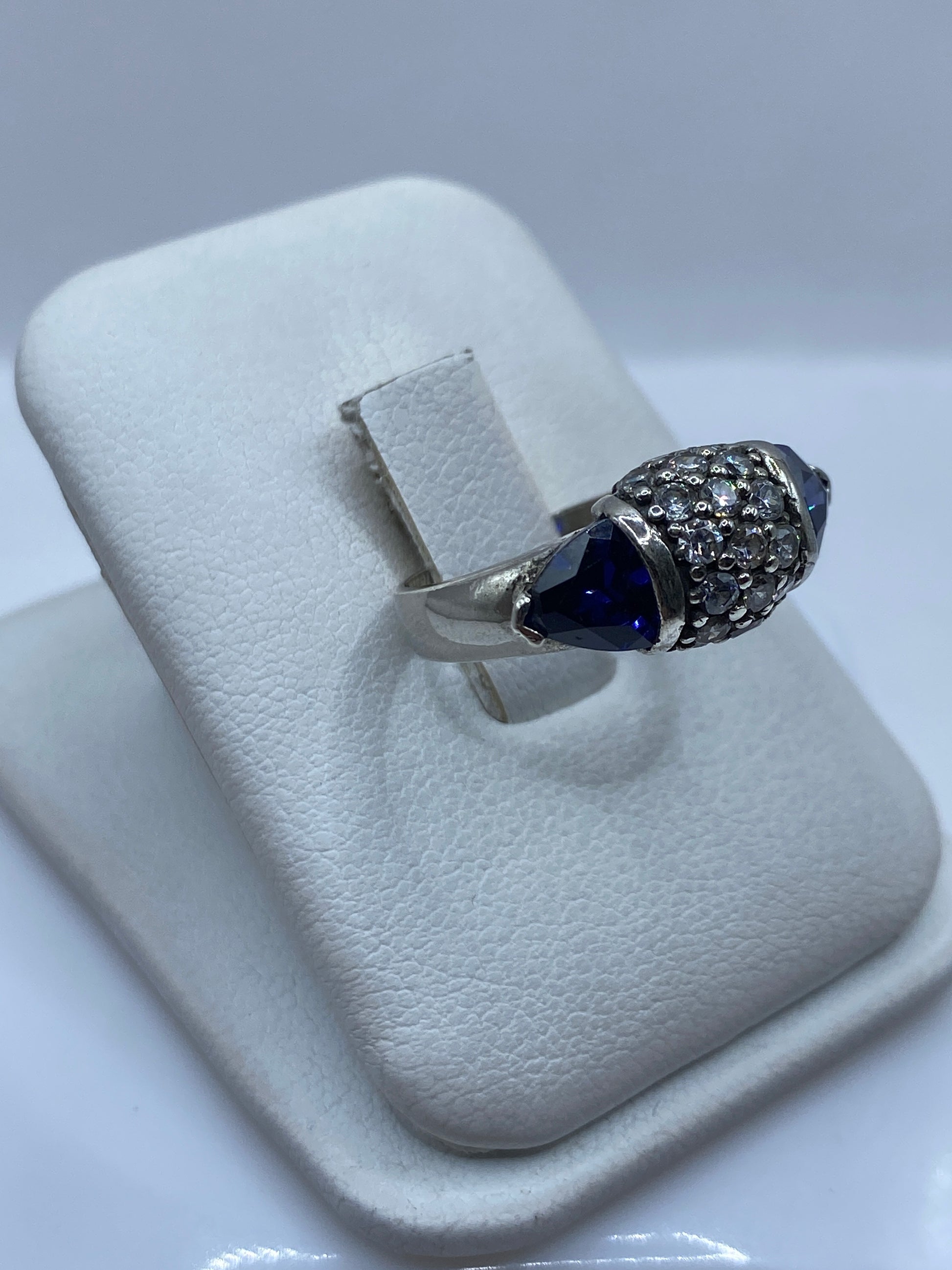Vista lateral del anillo de plata mostrando el detalle de engaste bilateral y la circonia azul
