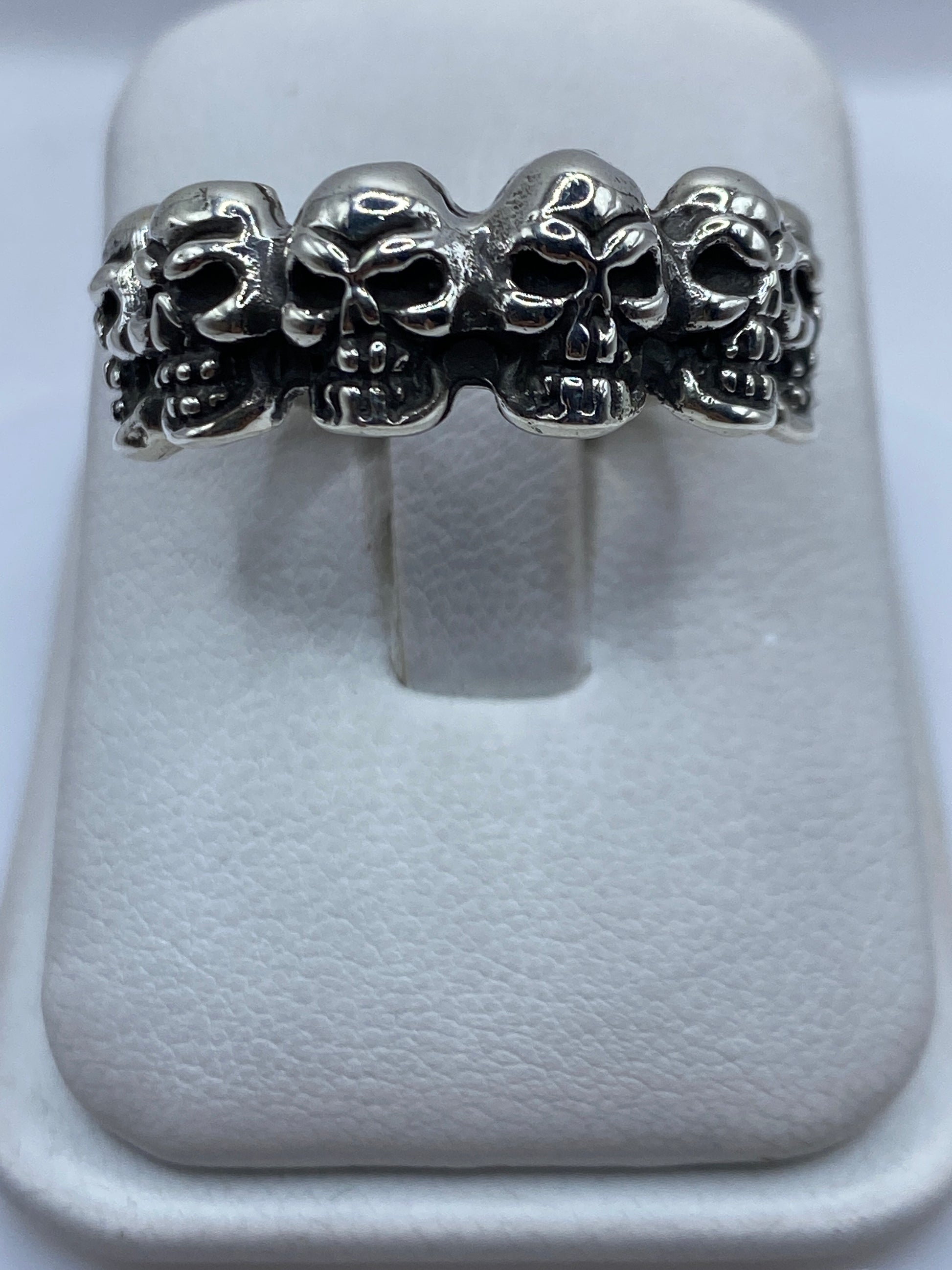 Anillo de plata .925 con cuatro calaveras talladas a mano, vista frontal de perfil