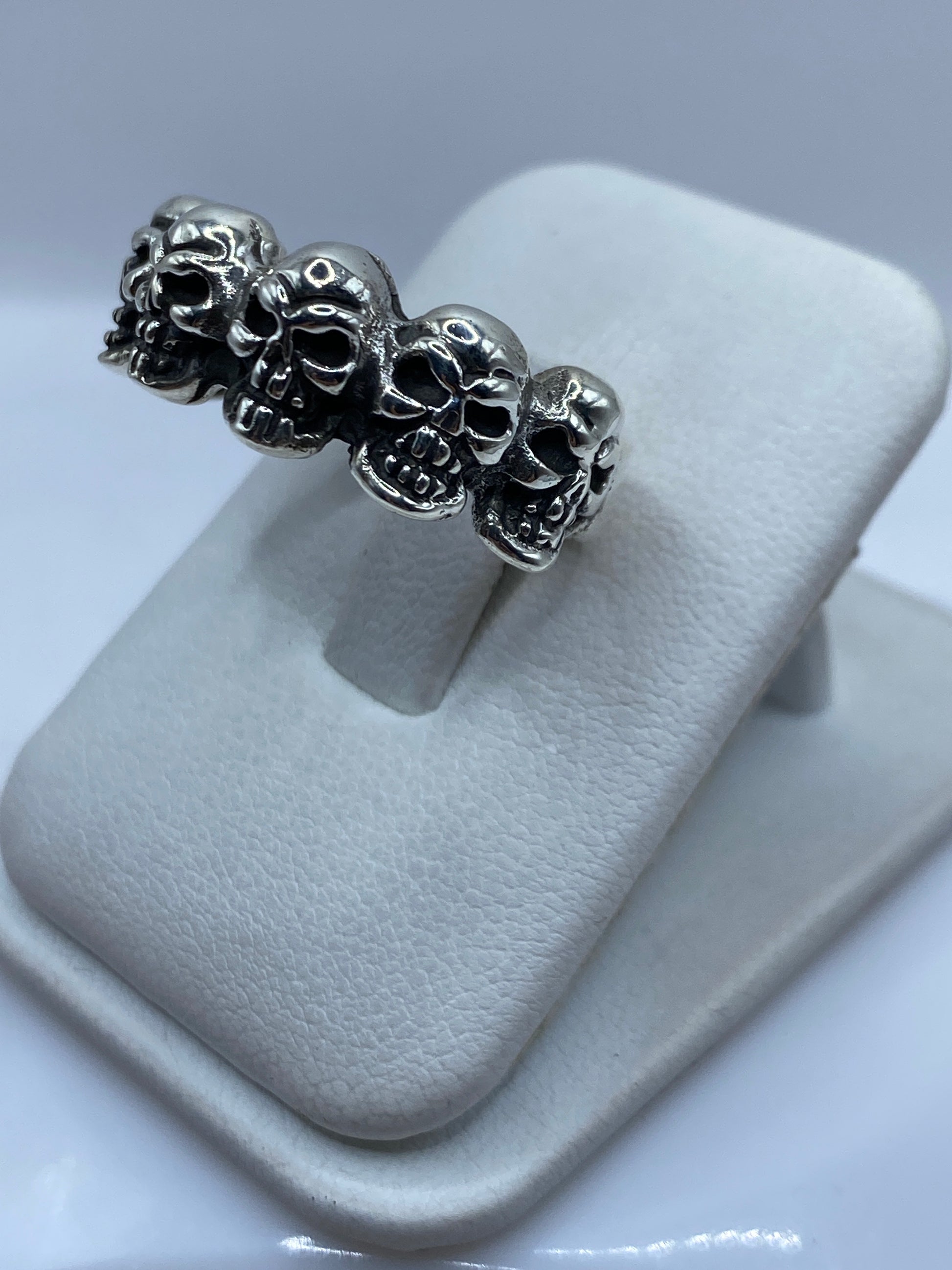Detalle de las calaveras del anillo mostrando el tallado fino de los ojos y mandíbula