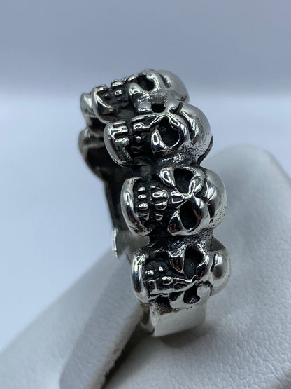 Anillo de calaveras en la mano de un hombre, vista superior mostrando presencia y peso