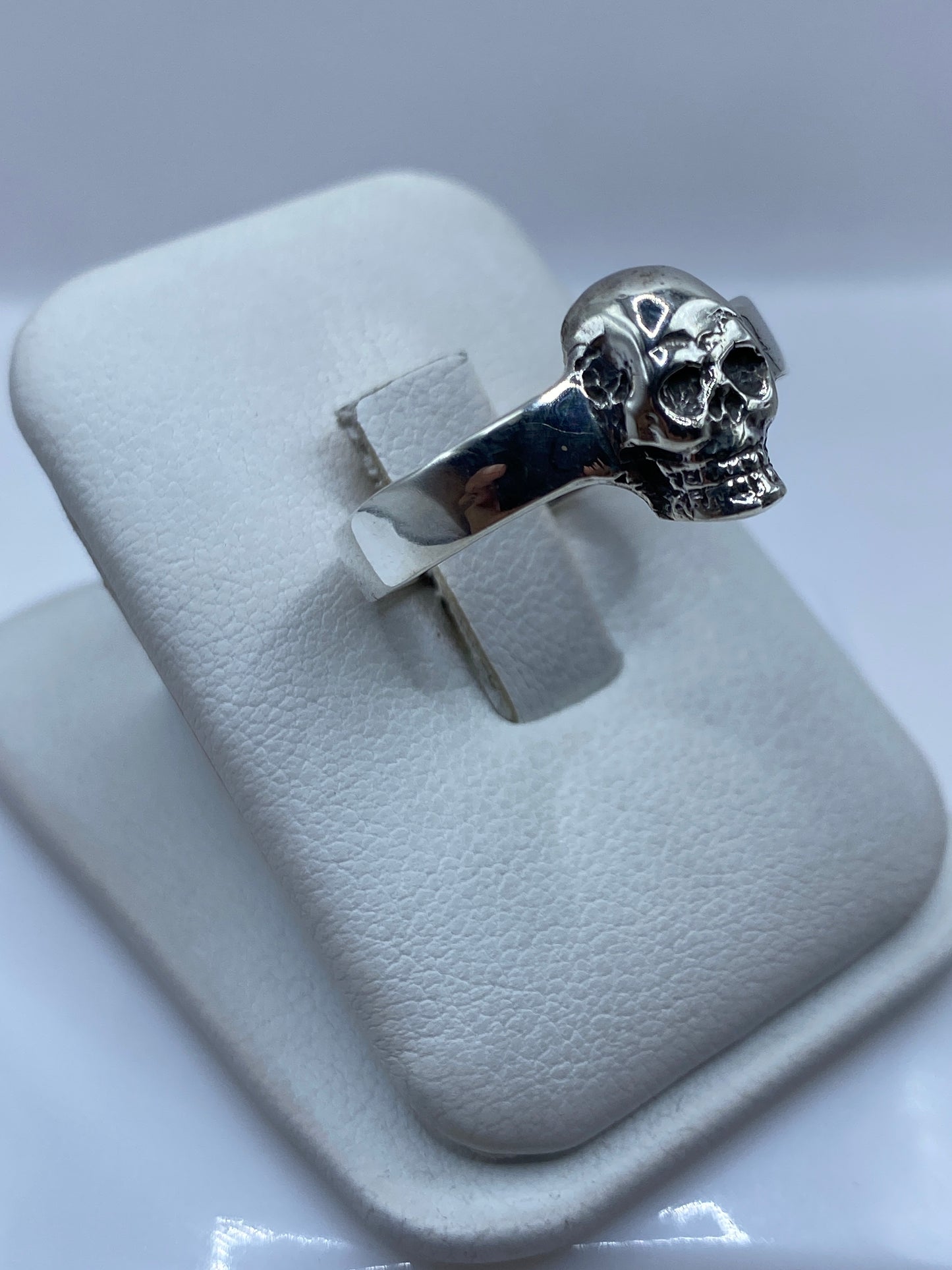 Detalle lateral del anillo calavera mostrando el escalpido artesanal del rostro