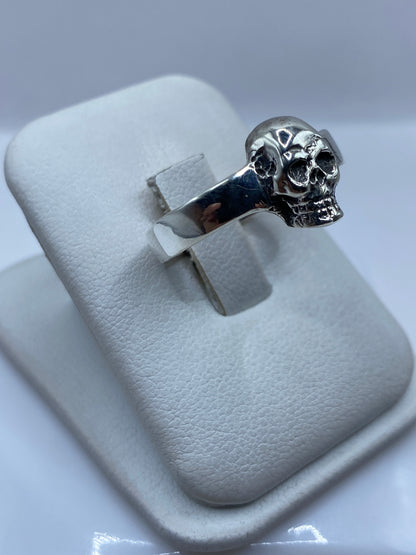 Detalle lateral del anillo calavera mostrando el escalpido artesanal del rostro