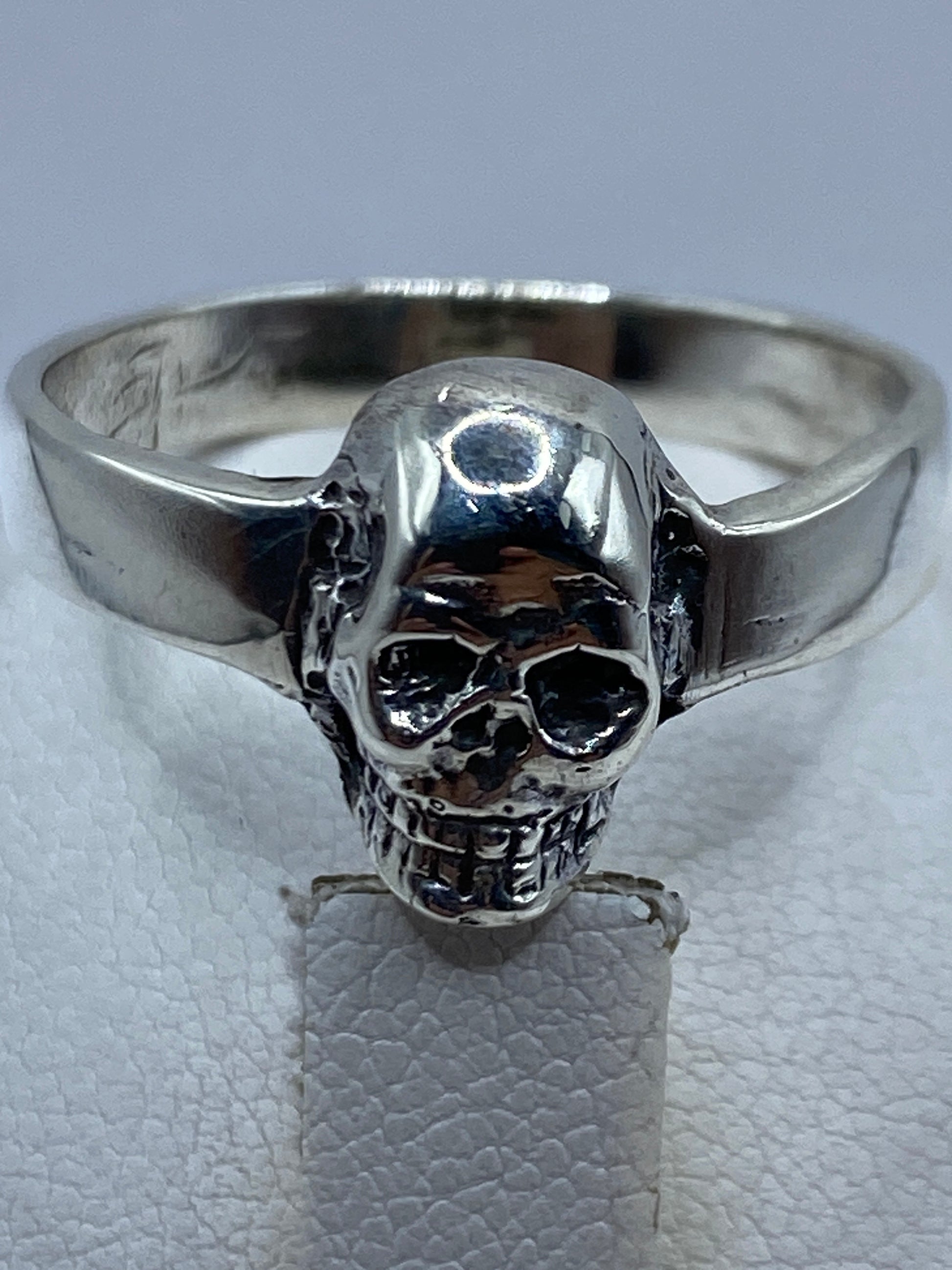Anillo calavera en la mano de un hombre, mostrando el tamaño y presencia real