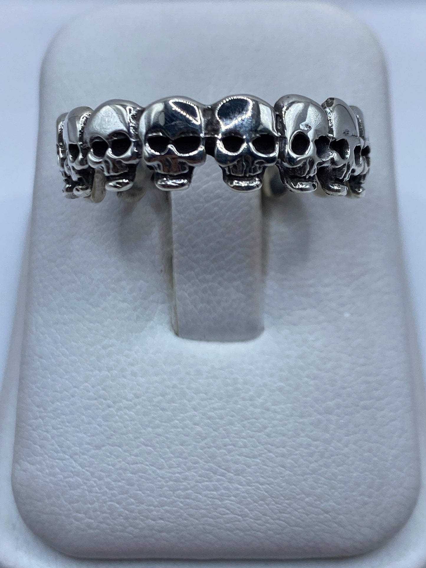 Anillo de plata sello macizo pulido en talla 12, vista frontal sobre almohada gris
