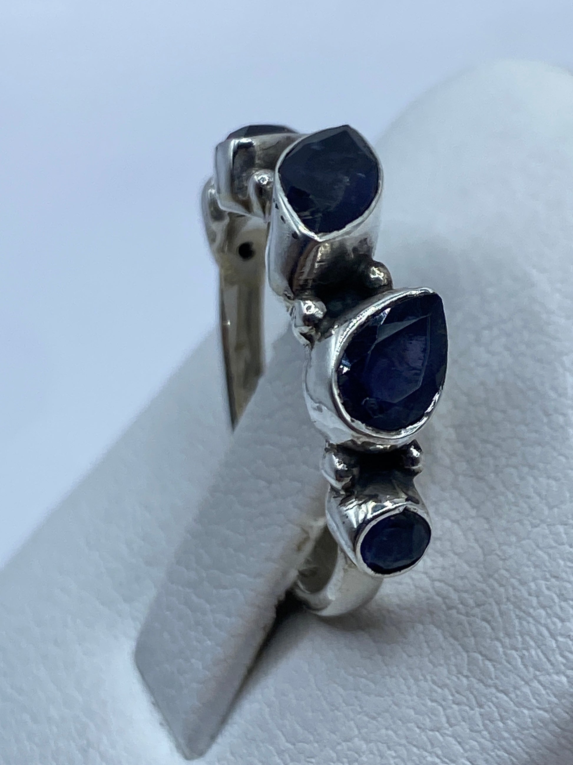 Detalle lateral del anillo en plata .925 mostrando la piedra azul y la banda moderna