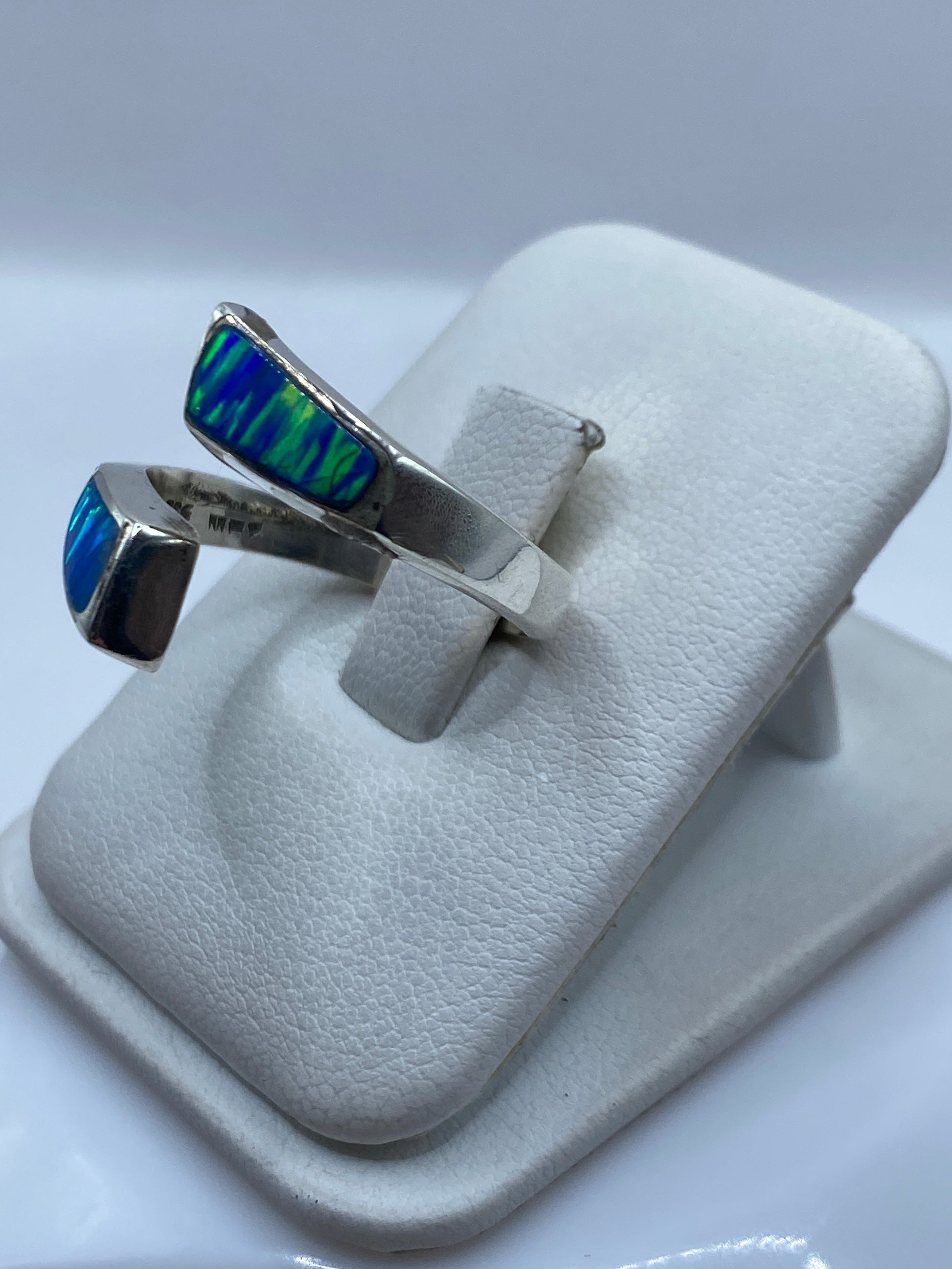 Detalle del ópalo azul con juego de colores verdes y azules en la mano