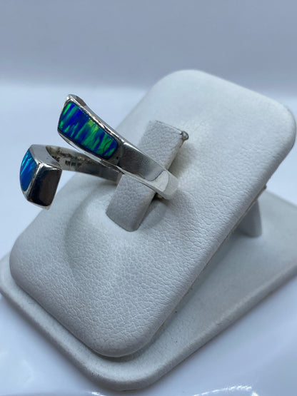 Detalle del ópalo azul con juego de colores verdes y azules en la mano