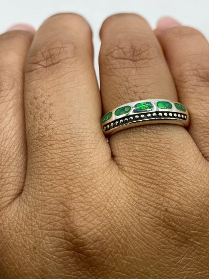 Anillo con ópalo de fuego puesto en dedo, mostrando el brillo y fuego de la piedra