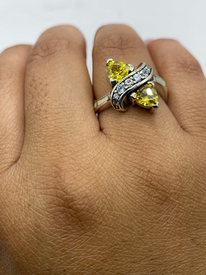 Anillo sobre fondo gris con sello .925 visible, ópalos brillando con colores únicos
