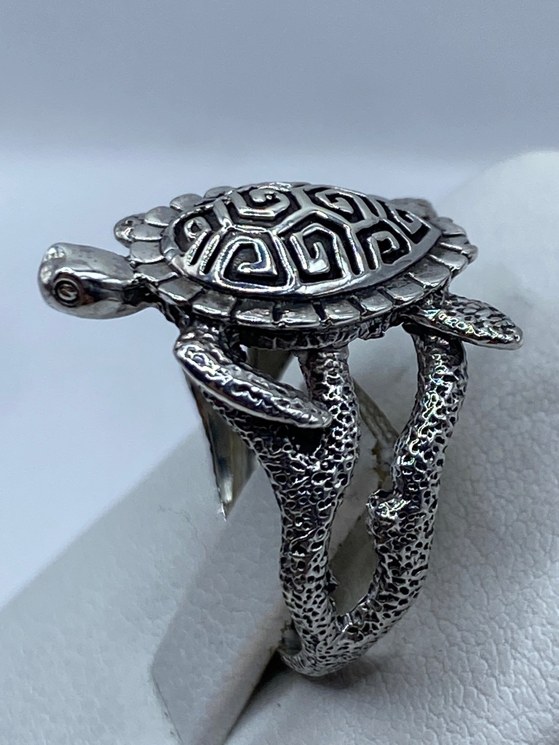 Detalle lateral del anillo tortuga mostrando el caparazón geométrico tallado a mano