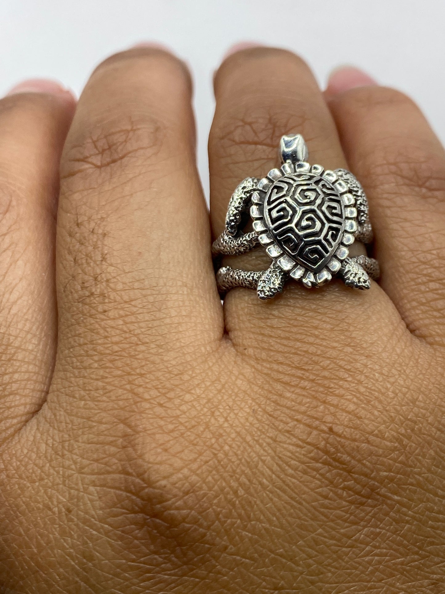 Anillo tortuga con pátina natural sobre fondo gris, sello .950 visible