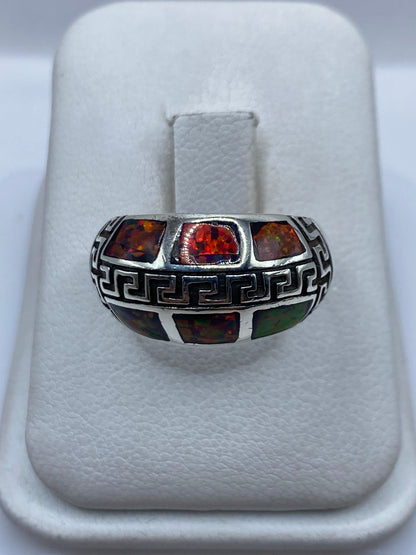 Anillo de plata .950 con ópalo de fuego multicolor y grecas étnicas, vista frontal en estuche blanco