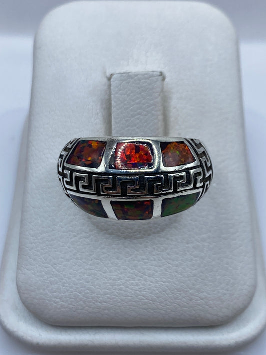 Anillo de plata .950 con ópalo de fuego multicolor y grecas étnicas, vista frontal en estuche blanco