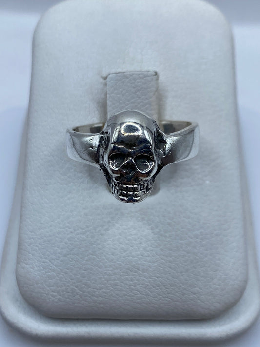 Anillo de plata calavera pulida sobre almohada blanca, talla 7