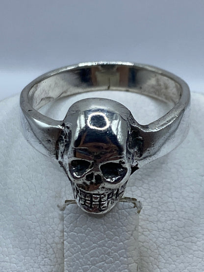 Anillo calavera de plata en mano de hombre adulto, uso diario