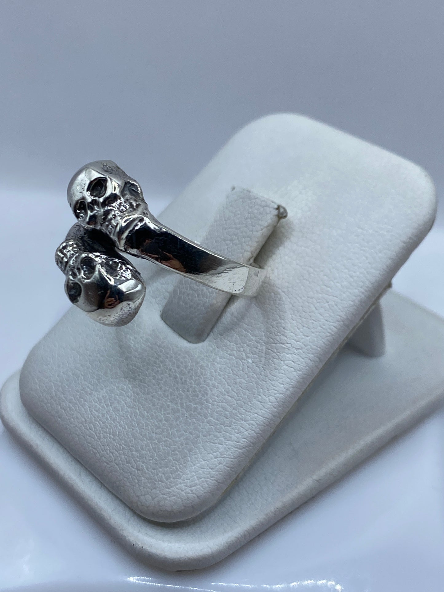 Vista frontal del anillo de calaveras con pulido brillante y oxidado en contraste