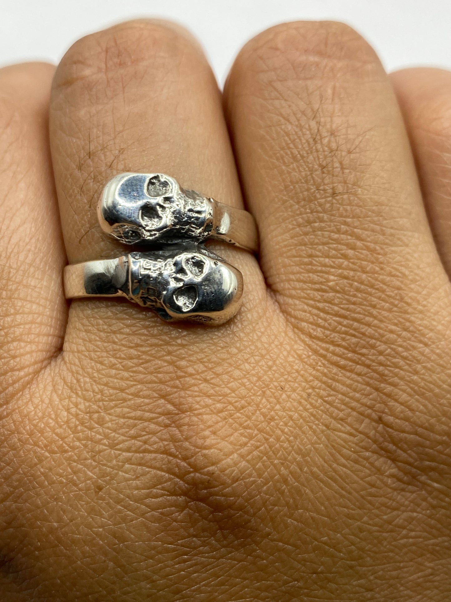 Anillo de calaveras sobre fondo neutro mostrando el sello 925 MEXICO