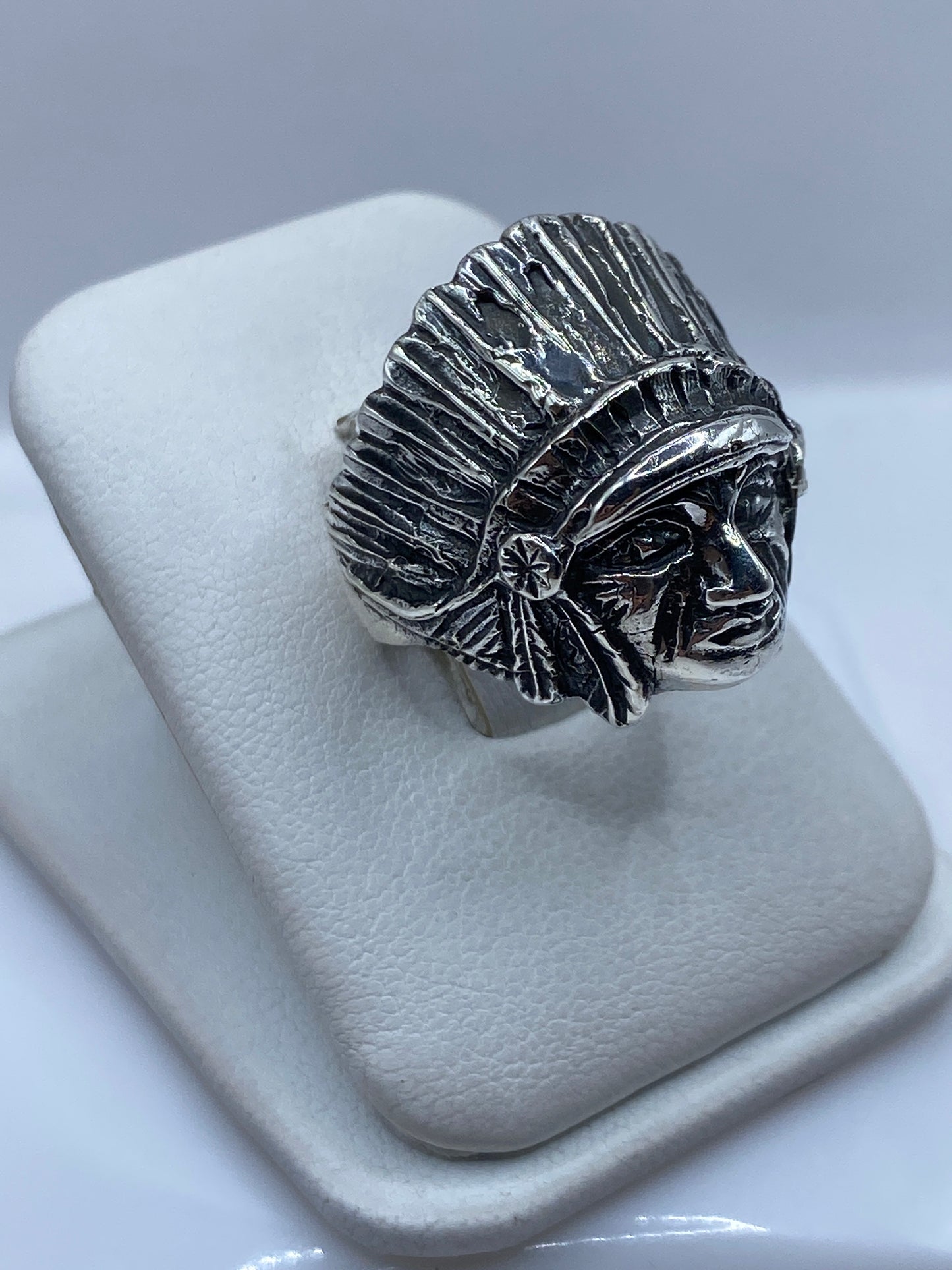 Anillo guerrero en perfil mostrando el tocado radiado y los detalles faciales