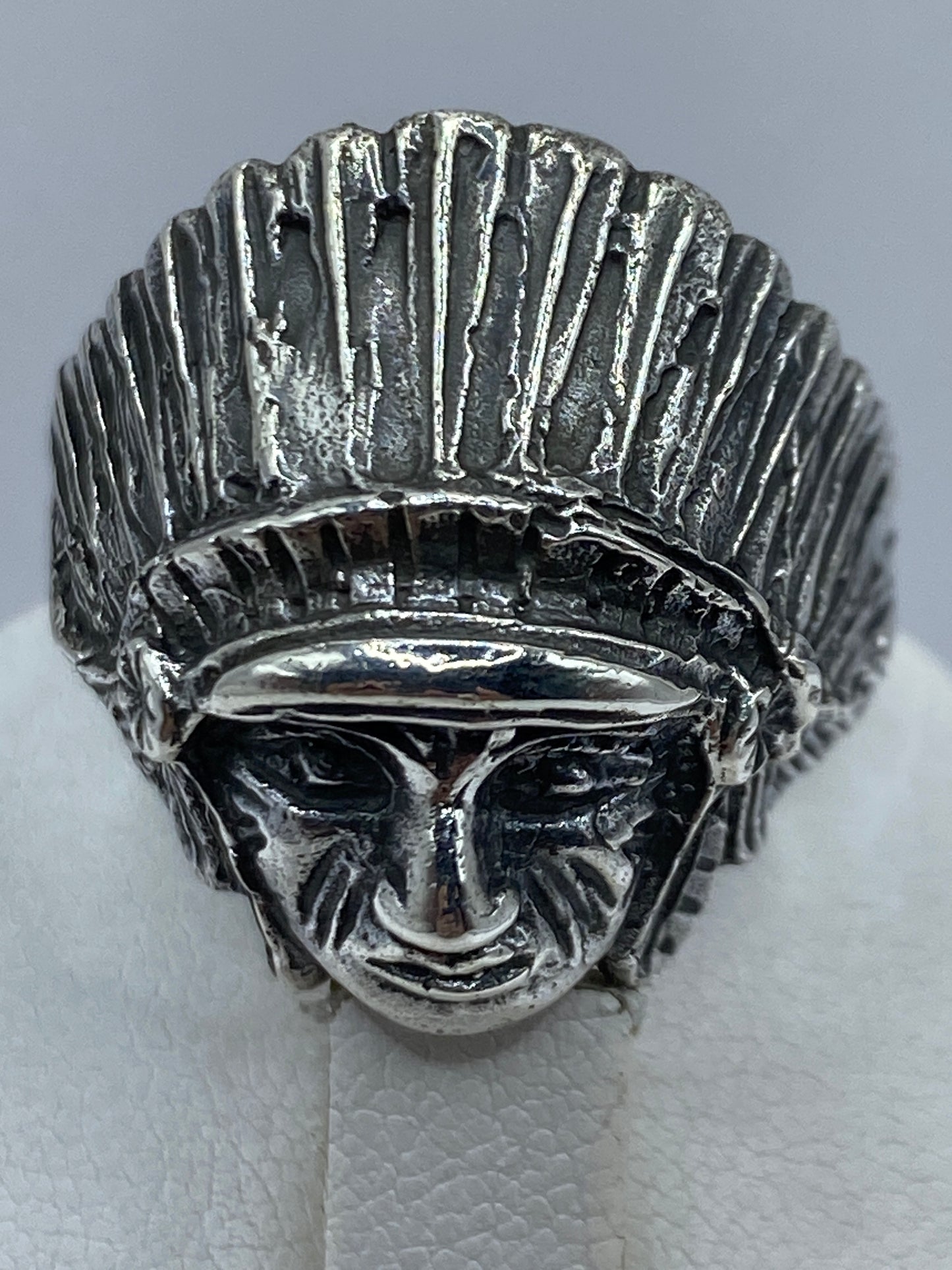 Detalle del guerrero prehispánico grabado en plata .950, tocado ritual de plumas