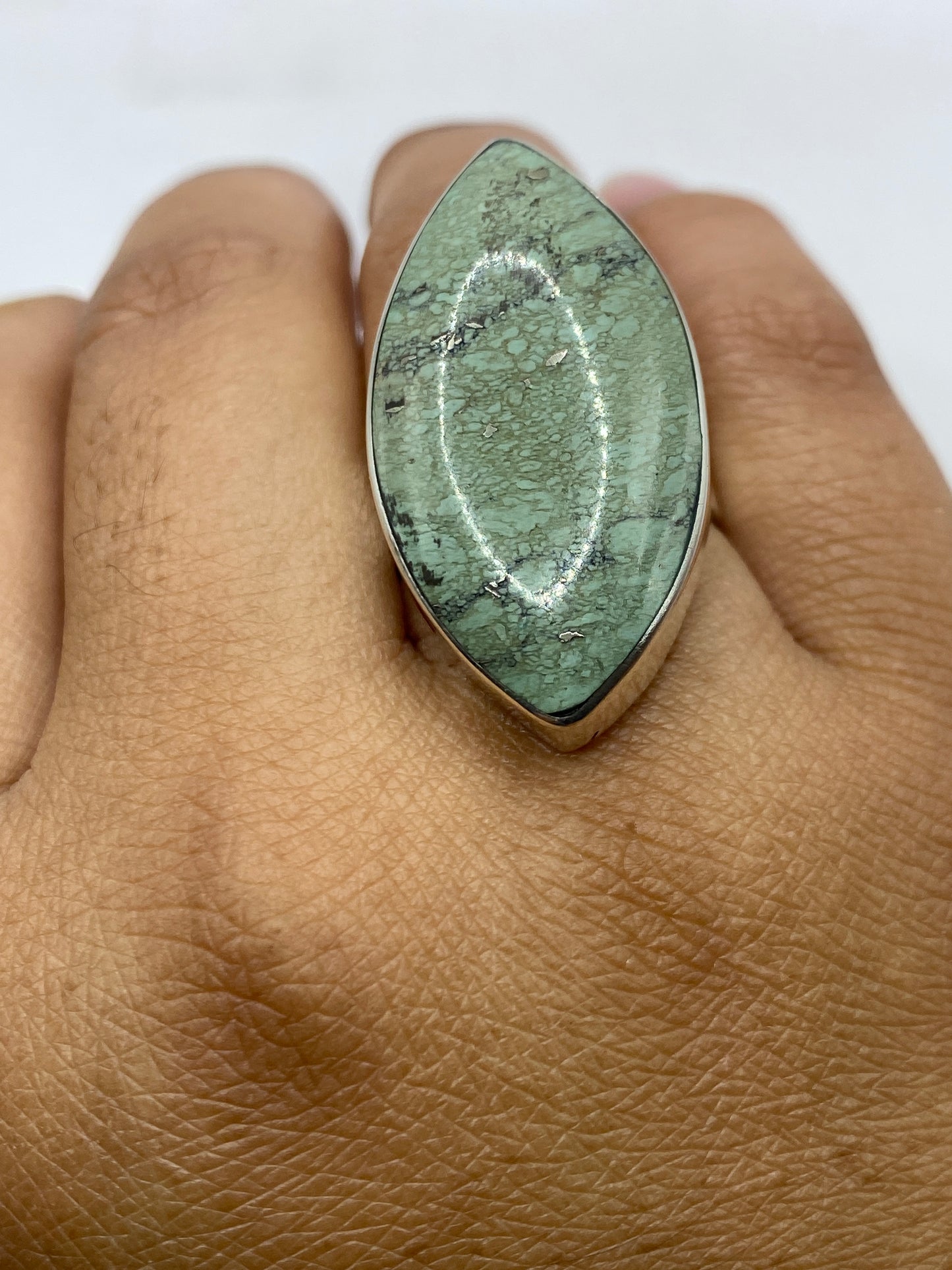Anillo sobre fondo gris mostrando el sello 950 en la banda de plata