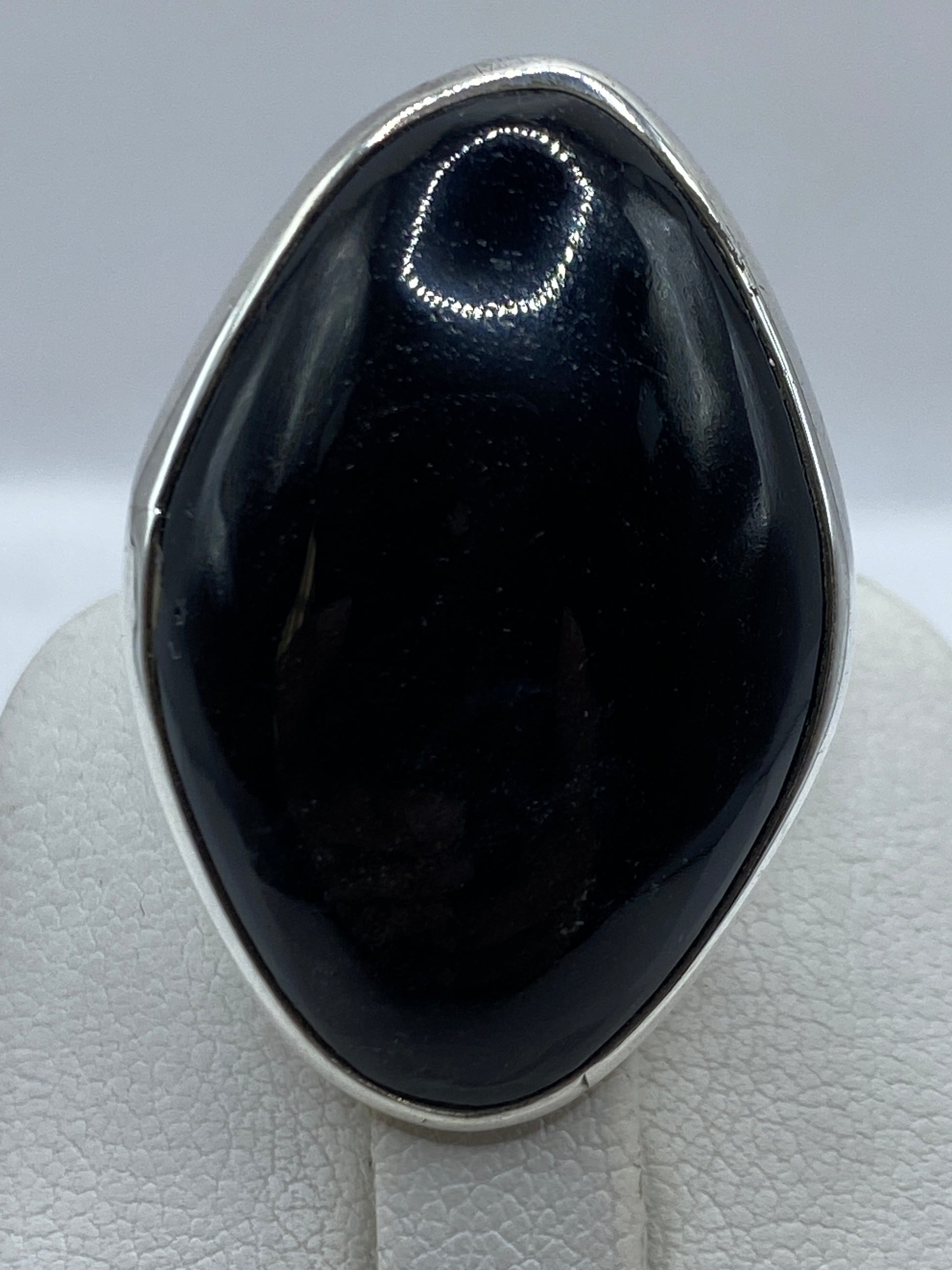 Anillo solitario de onix en la mano, mostrando el brillo profundo de la piedra