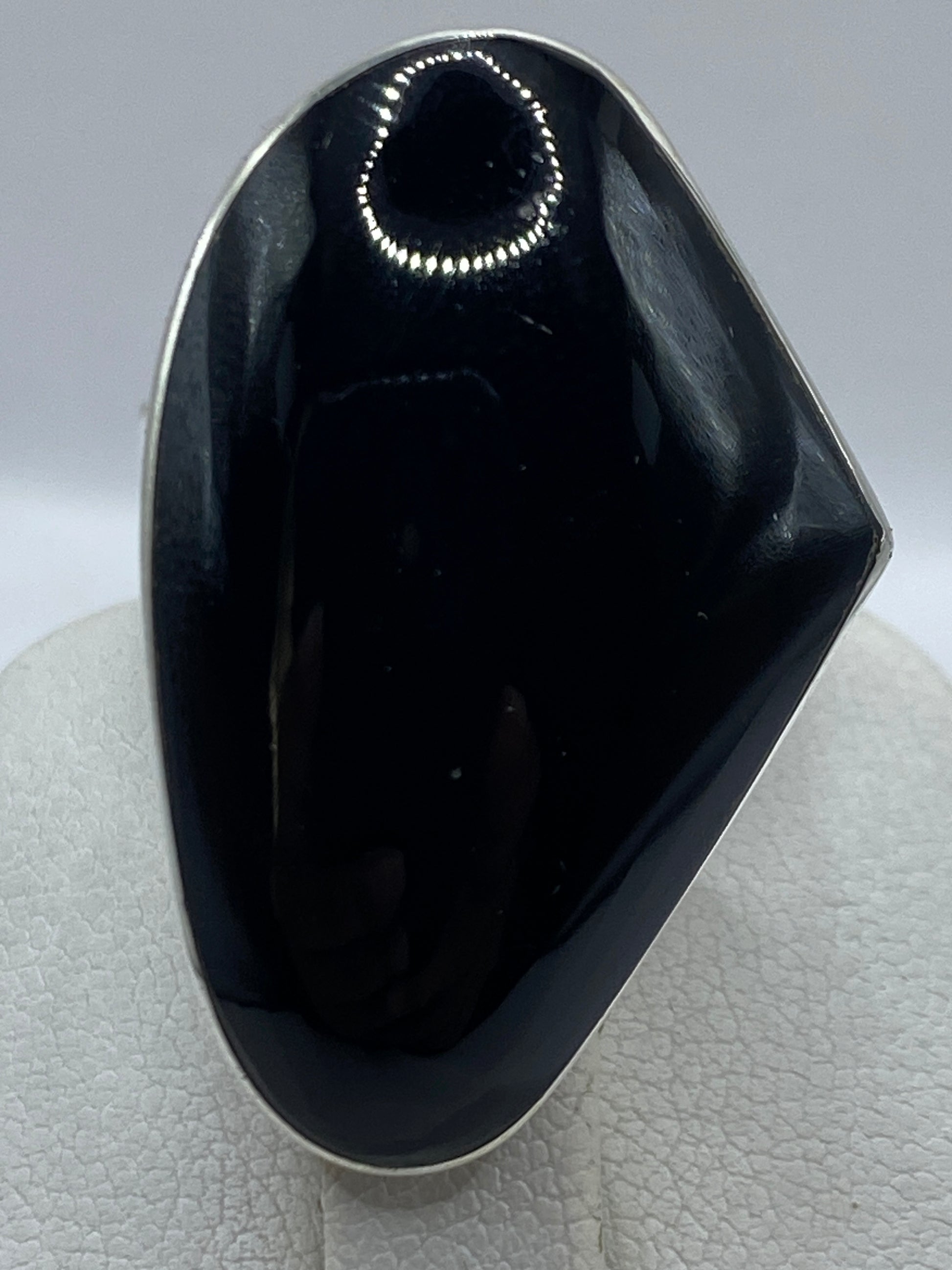 Detalle del ónix negro espejo en la mano, luz frontal