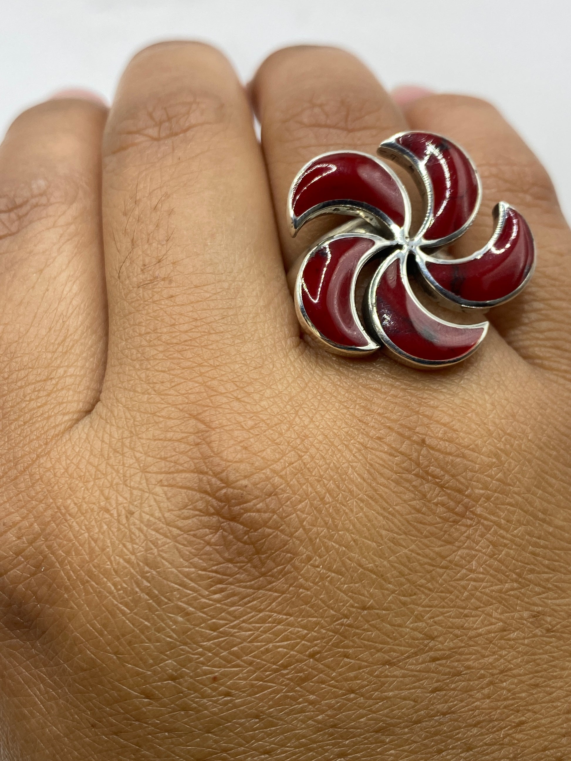 Anillo de coral rojo en dedo de mujer mostrando diseño completo y brillo de la plata