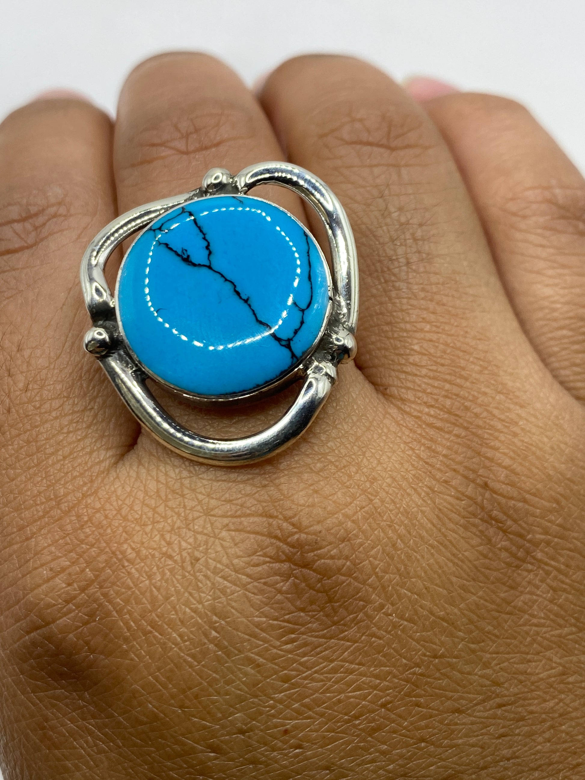Anillo sobre fondo blanco mostrando sello .950 y marco de plata pura