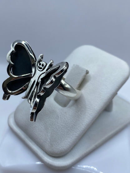 Anillo ajustable de plata con mariposa colocado en dedo de mujer