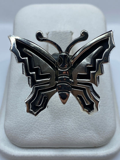 Anillo mariposa de plata .925 con geometría prehispánica, ajustable, visto de frente en caja presentadora