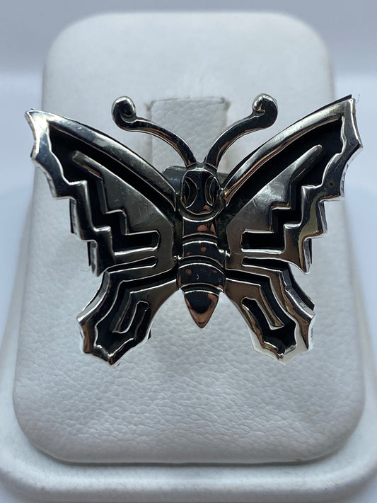 Anillo mariposa de plata .925 con geometría prehispánica, ajustable, visto de frente en caja presentadora