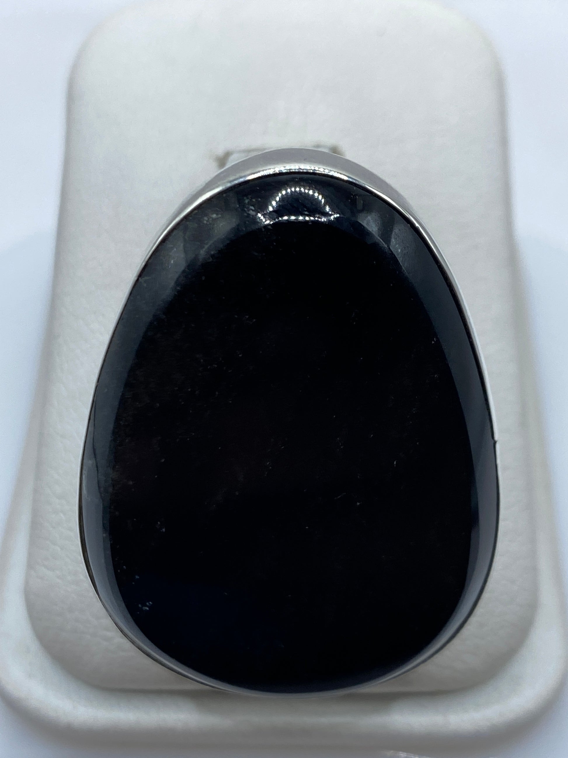 Anillo de plata .950 con ónix negro pulido en estuche blanco, vista frontal del engaste oval