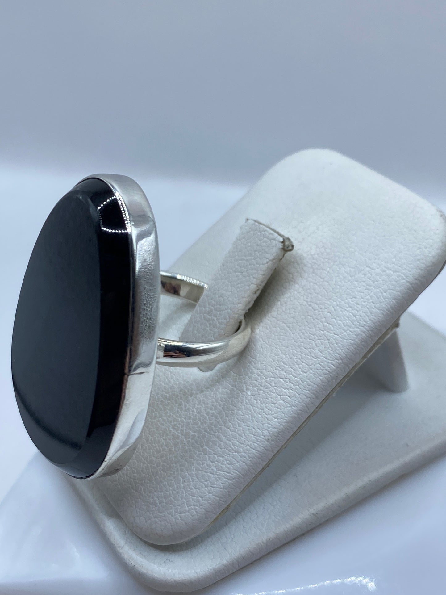 Anillo solitario ónix sobre mano femenina, mostrando el reflejo espejo del ónix negro